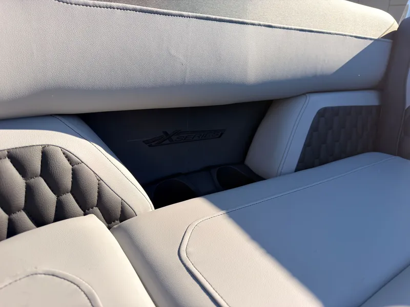 Slide: The Image of Close-up of a gray boat seat with "X Series" logo and cup holders. - 25