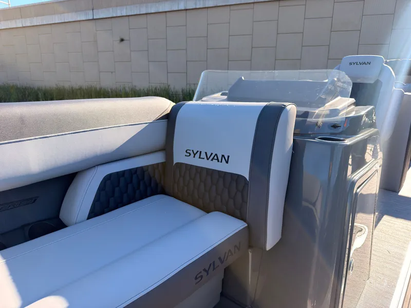 Slide: The Image of The image shows the interior of a 2027 Sylvan X3 LZ DH boat with cushioned seating. - 24