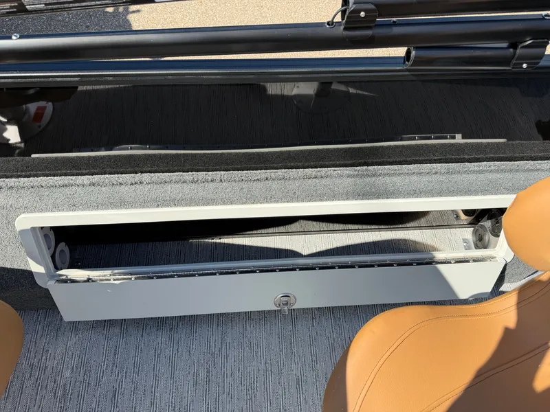 Slide: The Image of An open storage compartment on a 2027 Sylvan Q-20 Party Fish boat, featuring a beige seat. - 21