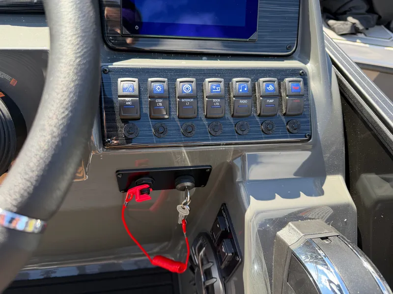 Slide: The Image of The image shows the dashboard of a Sylvan Q-20 Party Fish boat with various switches and a screen. - 17