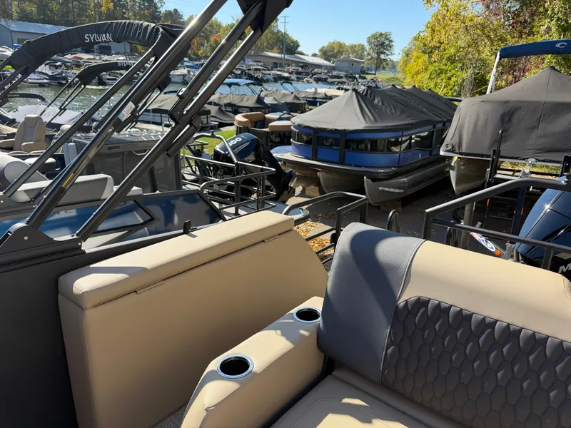 Slide: The Image of Sylvan X3 ULZ 2027: Luxurious pontoon boat in a marina with comfortable seating and cup holders. - 25