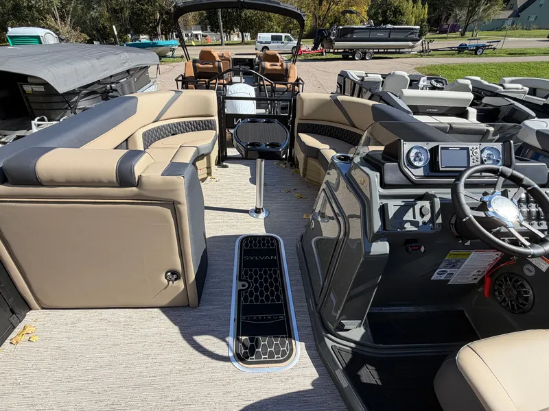 Slide: The Image of The image shows the interior of a Sylvan X3 ULZ pontoon boat with modern seating and helm console. - 13