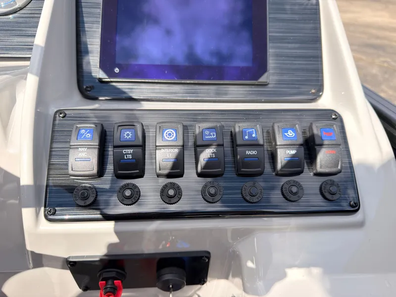 Slide: The Image of The dashboard of the 2027 Sylvan Q-20 Party Fish with various switches and a screen. - 37