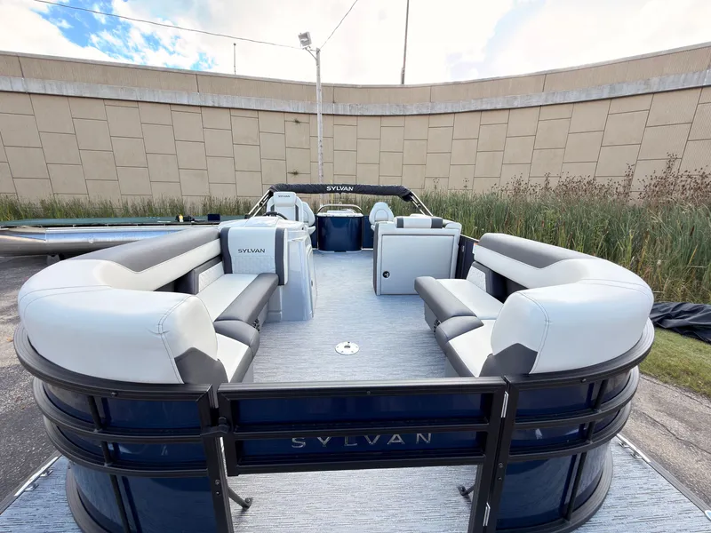 Slide: The Image of The image shows a Sylvan Q-20 Party Fish pontoon boat with gray and blue seating. - 9