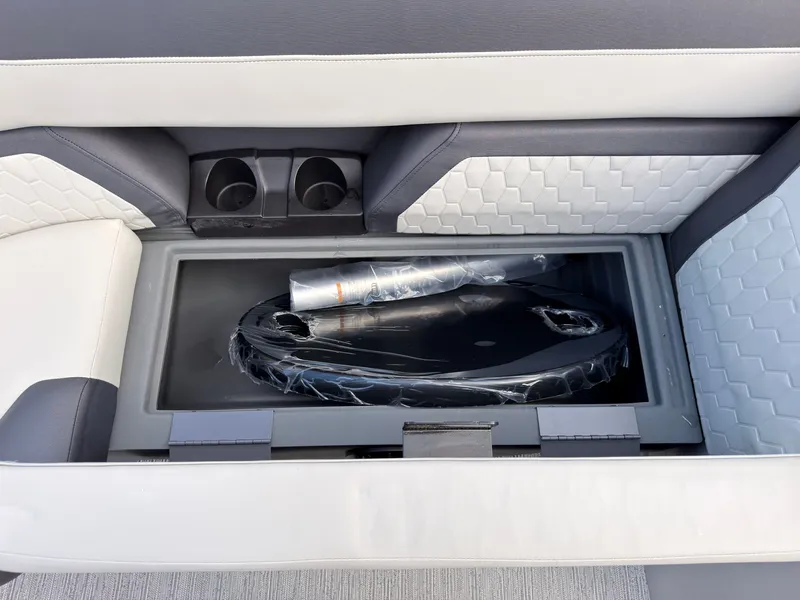 Slide: The Image of A storage compartment on a Sylvan Q-20 Party Fish boat with cup holders and cushioned seating. - 24
