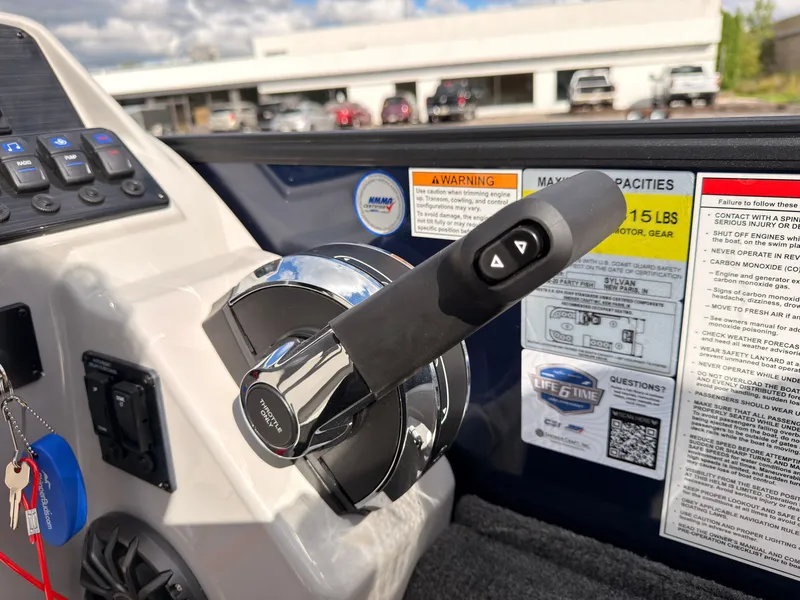 Slide: The Image of Close-up of the throttle lever on a 2027 Sylvan Q-20 Party Fish, with warning and capacity stickers. - 42