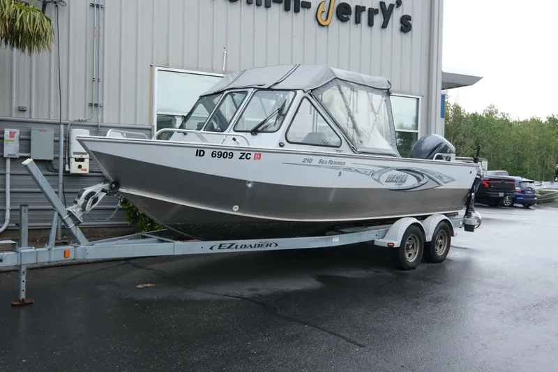 The Image of 2016 Hewescraft 210 Sea Runner ET Hardtop on trailer outside a building. - 1