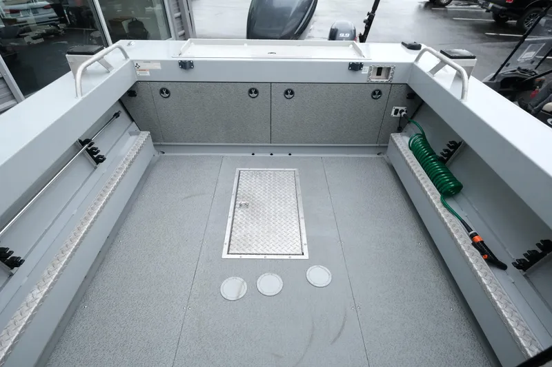 Slide: The Image of 2016 Hewescraft 210 Sea Runner ET Hardtop boat interior with storage and hose. - 9