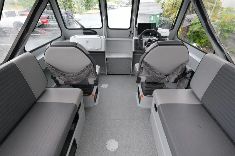 Slide: The Image of Interior of a 2016 Hewescraft 210 Sea Runner ET Hardtop boat, featuring seating and helm. - 10