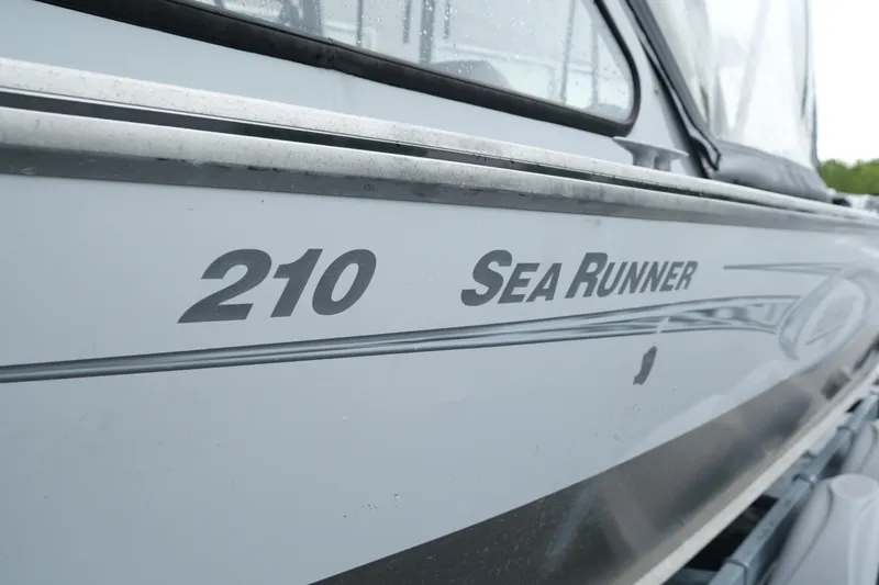 Slide: The Image of 2016 Hewescraft 210 Sea Runner ET Hardtop boat side view with model name. - 6