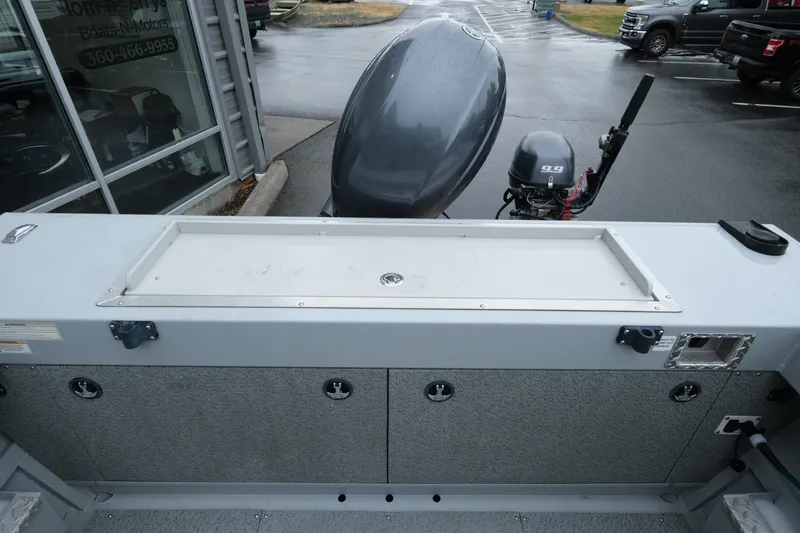 Slide: The Image of 2016 Hewescraft 210 Sea Runner ET Hardtop boat with dual outboard motors in a parking lot. - 17
