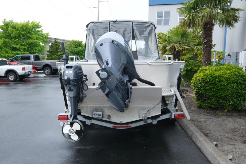 Slide: The Image of 2016 Hewescraft 210 Sea Runner ET Hardtop boat with dual outboard motors in a parking lot. - 5