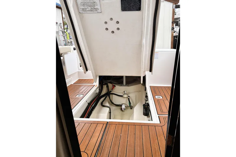 Slide: The Image of 2022 Ranger Tugs R-27 engine compartment with teak flooring and visible mechanical components. - 16