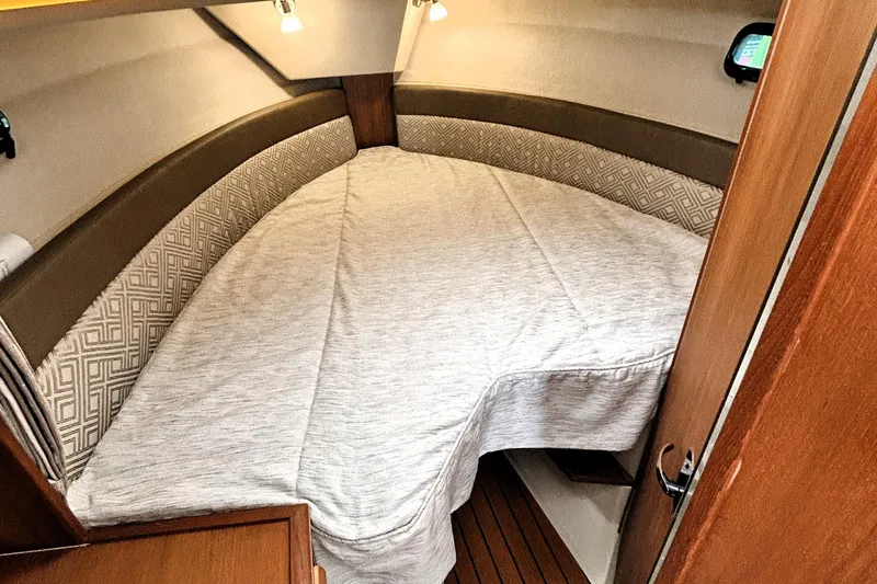Slide: The Image of Cozy cabin interior of 2022 Ranger Tugs R-27 with comfortable bedding and ambient lighting. - 11