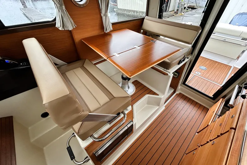 Slide: The Image of Interior of 2022 Ranger Tugs R-27, featuring a cozy dining area with wood accents. - 7