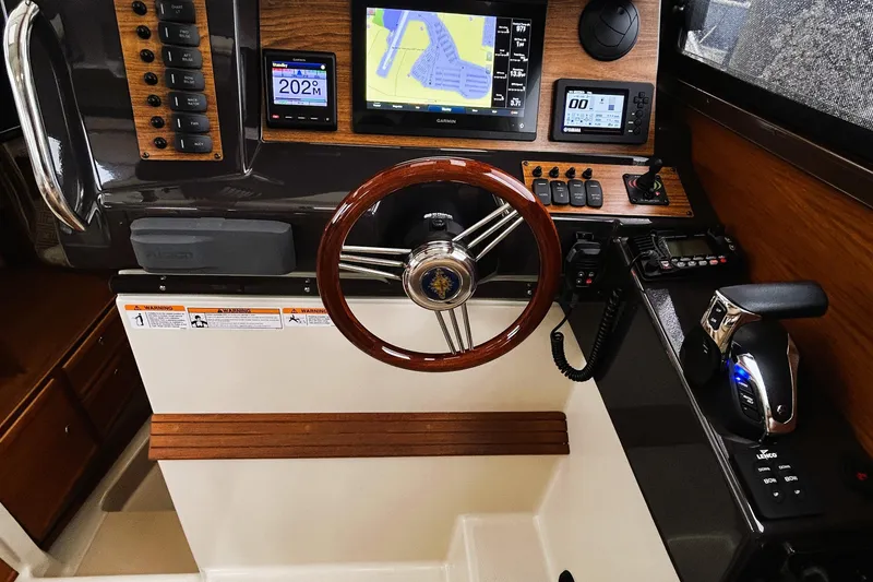 Slide: The Image of 2022 Ranger Tugs R-27 helm with wooden steering wheel and advanced navigation displays. - 4