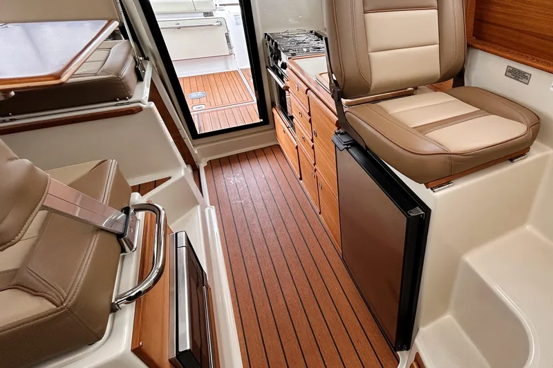 Slide: The Image of Interior of 2022 Ranger Tugs R-27 boat with seating, kitchenette, and wood flooring. - 5