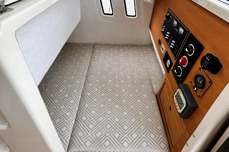 Slide: The Image of 2022 Ranger Tugs R-27 cabin interior with control panel and patterned flooring. - 14