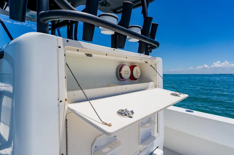 Slide: The Image of 2016 Andros 32 Offshore boat with open storage compartment, set against a clear blue ocean backdrop. - 68
