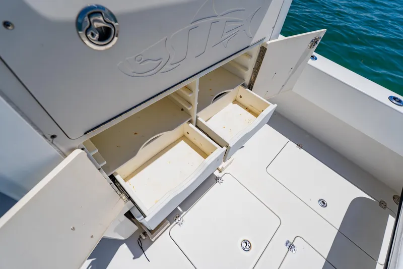Slide: The Image of Open storage compartments on a 2016 Andros 32 Offshore boat, with ocean in the background. - 69