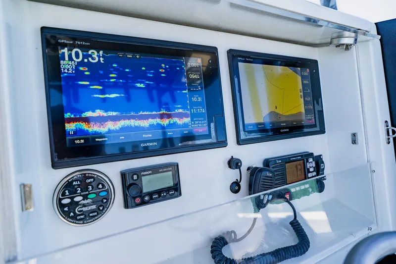 Slide: The Image of 2016 Andros 32 Offshore boat dashboard with Garmin navigation displays and communication equipment. - 48