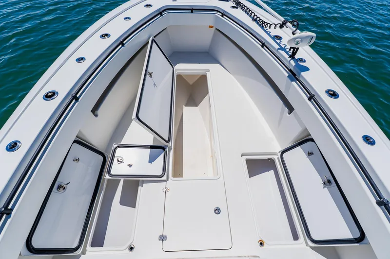 Slide: The Image of 2016 Andros 32 Offshore boat deck with open storage compartments on calm water. - 28