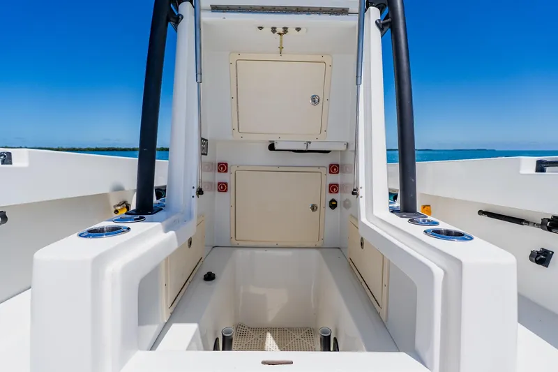 Slide: The Image of 2016 Andros 32 Offshore boat interior with storage compartments and rod holders, under clear blue sky. - 38