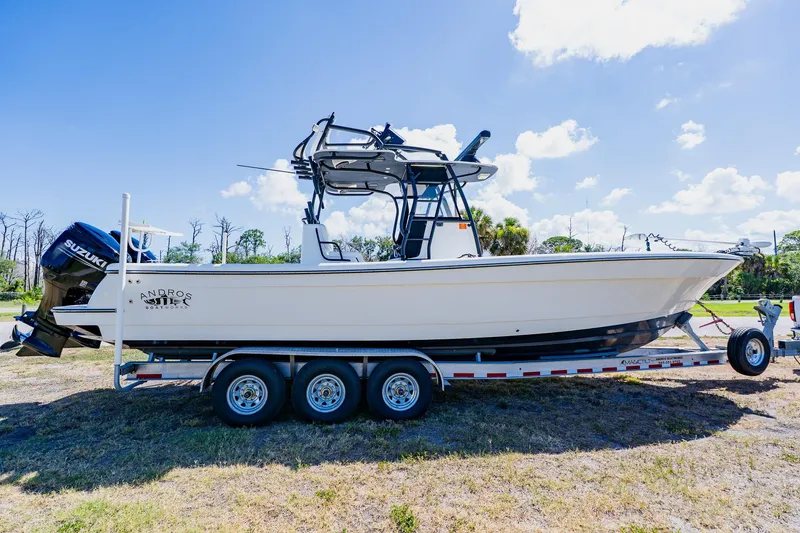 Slide: The Image of 2016 Andros 32 Offshore boat on trailer, featuring Suzuki engines, under a clear blue sky. - 3