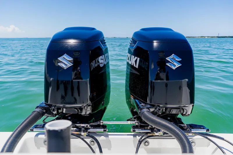 Slide: The Image of Twin Suzuki outboard motors on a 2016 Andros 32 Offshore boat in clear blue water. - 81