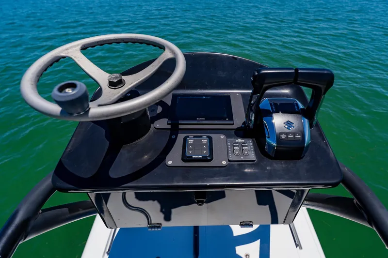 Slide: The Image of Steering console of 2016 Andros 32 Offshore boat with controls and display on open water. - 84
