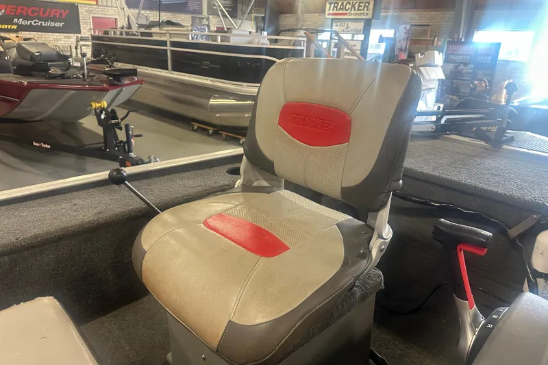 Slide: The Image of 2015 Tracker Panfish 16 boat seat in showroom, featuring red and gray upholstery. - 7