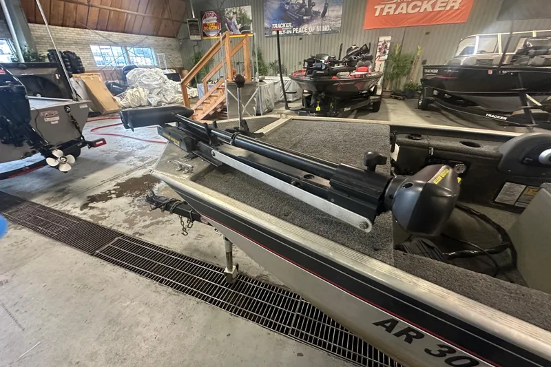 Slide: The Image of 2015 Tracker Panfish 16 boat in showroom, featuring trolling motor and carpeted deck. - 15