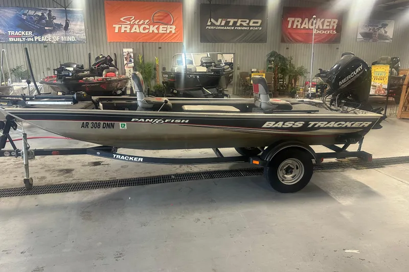 Slide: The Image of 2015 Tracker Panfish 16 boat on trailer in showroom with promotional banners. - 2