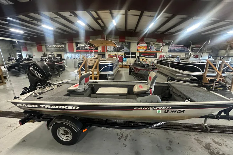 The Image of 2015 Tracker Panfish 16 boat in showroom, featuring Mercury engine and fishing seats. - 0