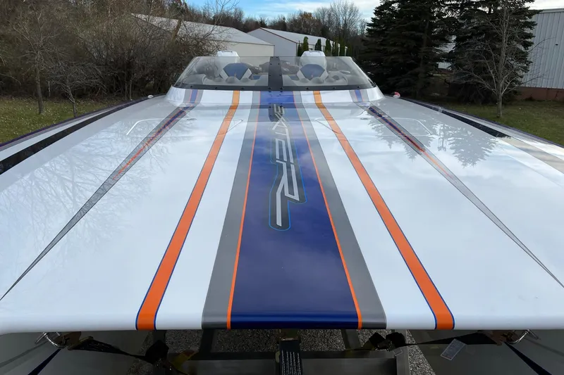 Slide: The Image of 2023 Skater 318 boat with sleek design, featuring bold orange and blue stripes. - 3