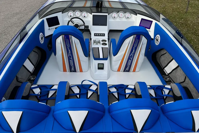 Slide: The Image of 2023 Skater 318 boat interior with blue and white seating, modern dashboard, and vibrant design. - 5