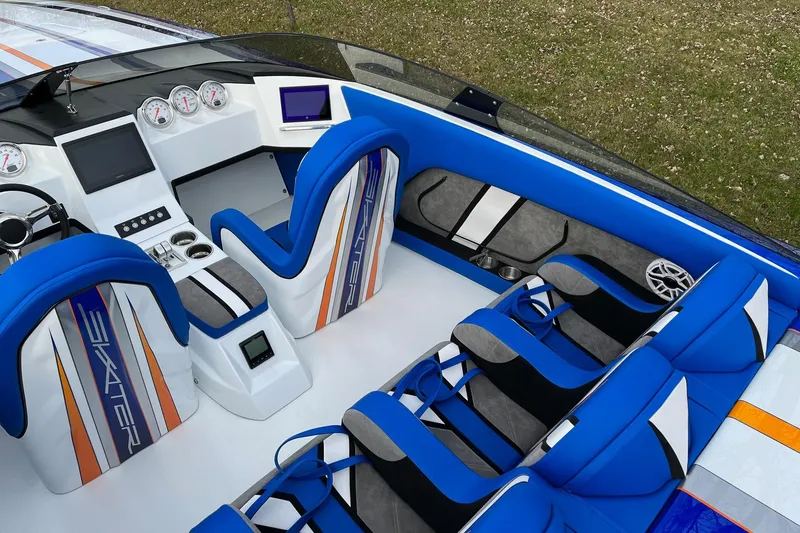 Slide: The Image of Interior of 2023 Skater 318 boat with blue and orange seating and modern dashboard. - 6