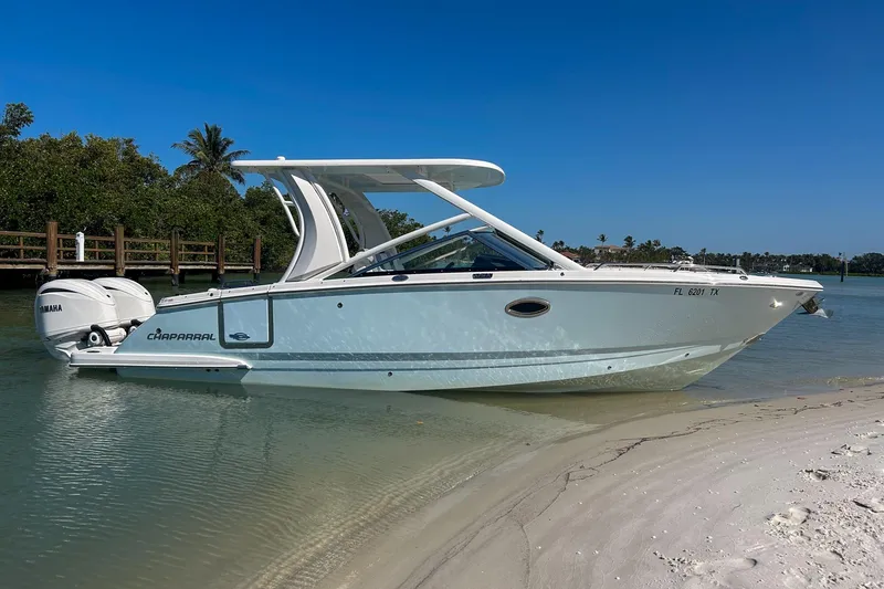 The Image of 2024 Chaparral 280 OSX boat docked on sandy shore under clear blue sky. - 0