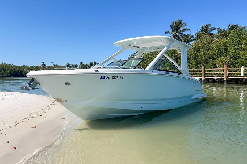 Slide: The Image of 2024 Chaparral 280 OSX boat docked on sandy beach with clear blue sky. - 3
