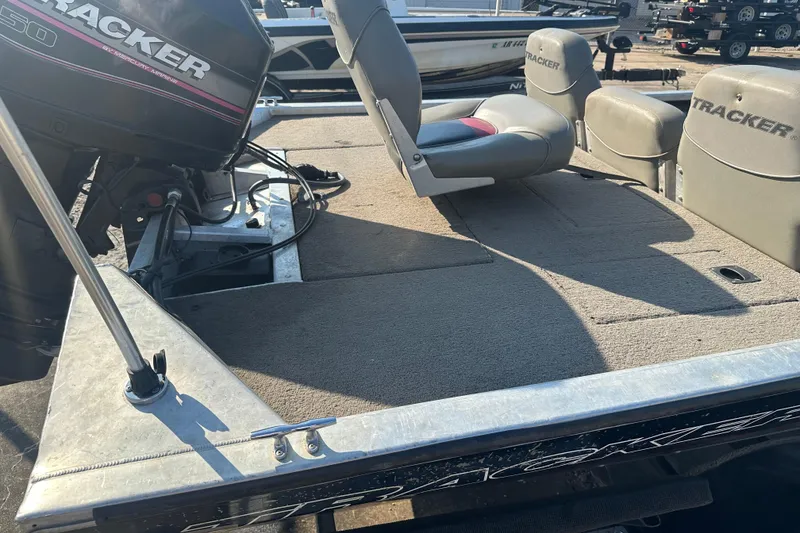 Slide: The Image of 1999 Tracker Pro Team 185 boat interior with seating and motor, in a sunny outdoor setting. - 9