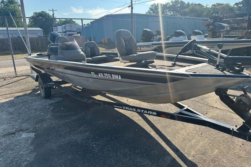 Slide: The Image of 1999 Tracker Pro Team 185 fishing boat on a trailer in a sunny outdoor setting. - 4