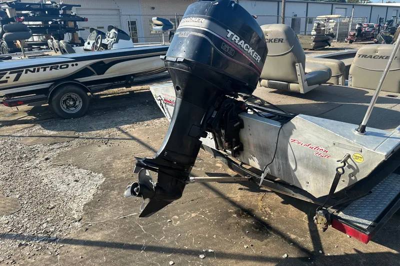 Slide: The Image of 1999 Tracker Pro Team 185 boat with outboard motor in a marina setting. - 8
