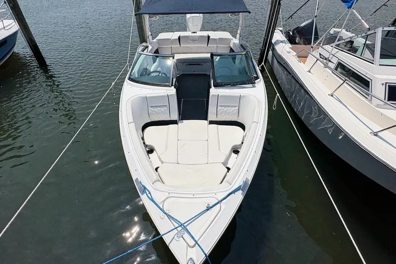 Slide: The Image of 2022 Four Winns H4 OB boat docked, featuring spacious seating and sleek design. - 2