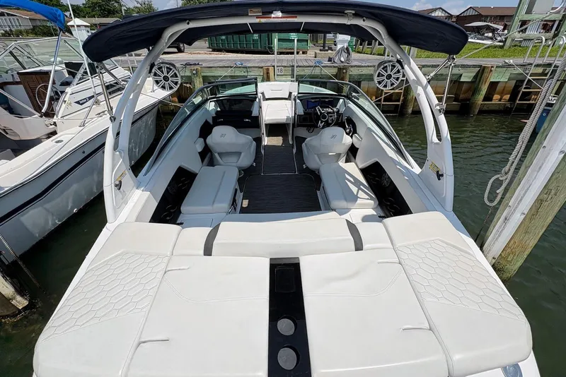 Slide: The Image of 2022 Four Winns H4 OB boat with spacious seating and modern design at a dock. - 10