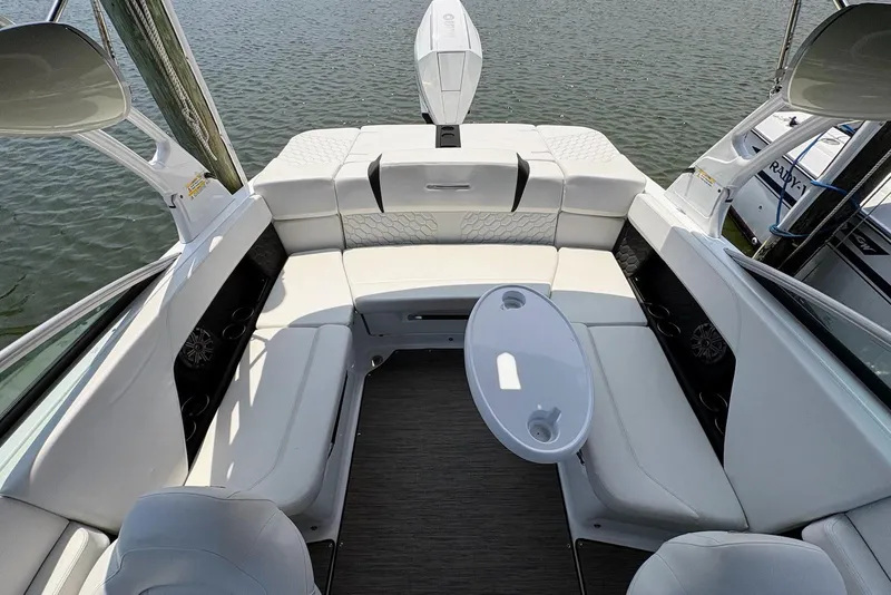 Slide: The Image of 2022 Four Winns H4 OB boat interior with white seating and table on the water. - 12
