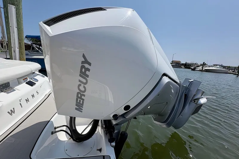 Slide: The Image of 2022 Four Winns H4 OB boat with Mercury outboard motor docked by the water. - 3