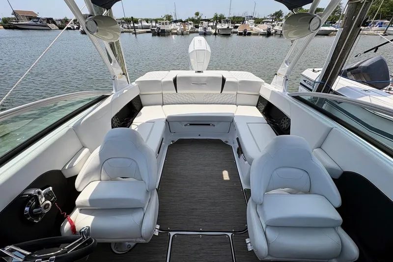 Slide: The Image of 2022 Four Winns H4 OB boat interior with white seating, docked at marina. - 13