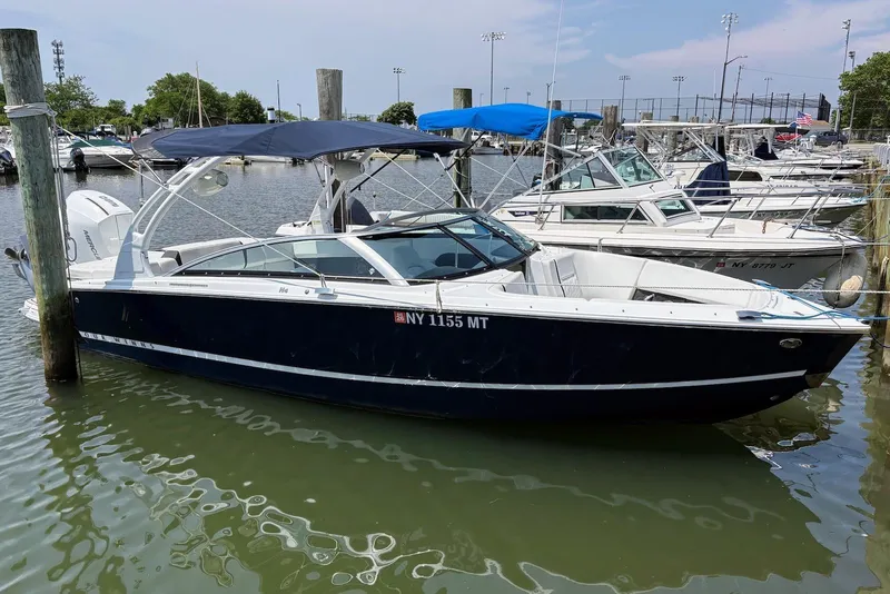 The Image of 2022 Four Winns H4 OB boat docked in a marina under a clear sky. - 0