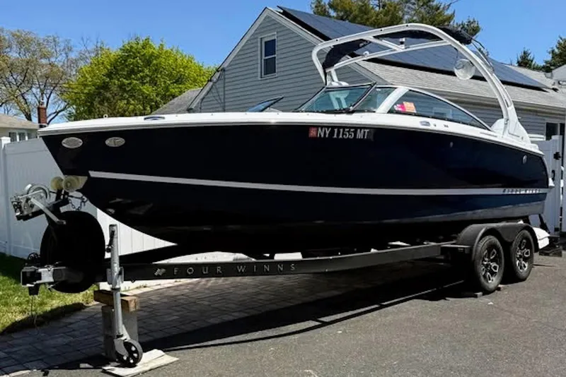 Slide: The Image of 2022 Four Winns H4 OB boat on trailer, parked in residential driveway. - 14