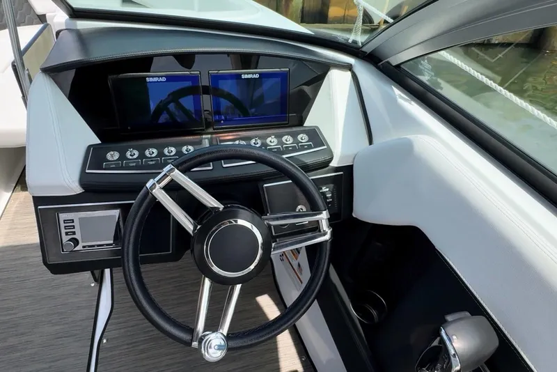 Slide: The Image of 2022 Four Winns H4 OB boat dashboard with steering wheel and dual Simrad displays. - 7